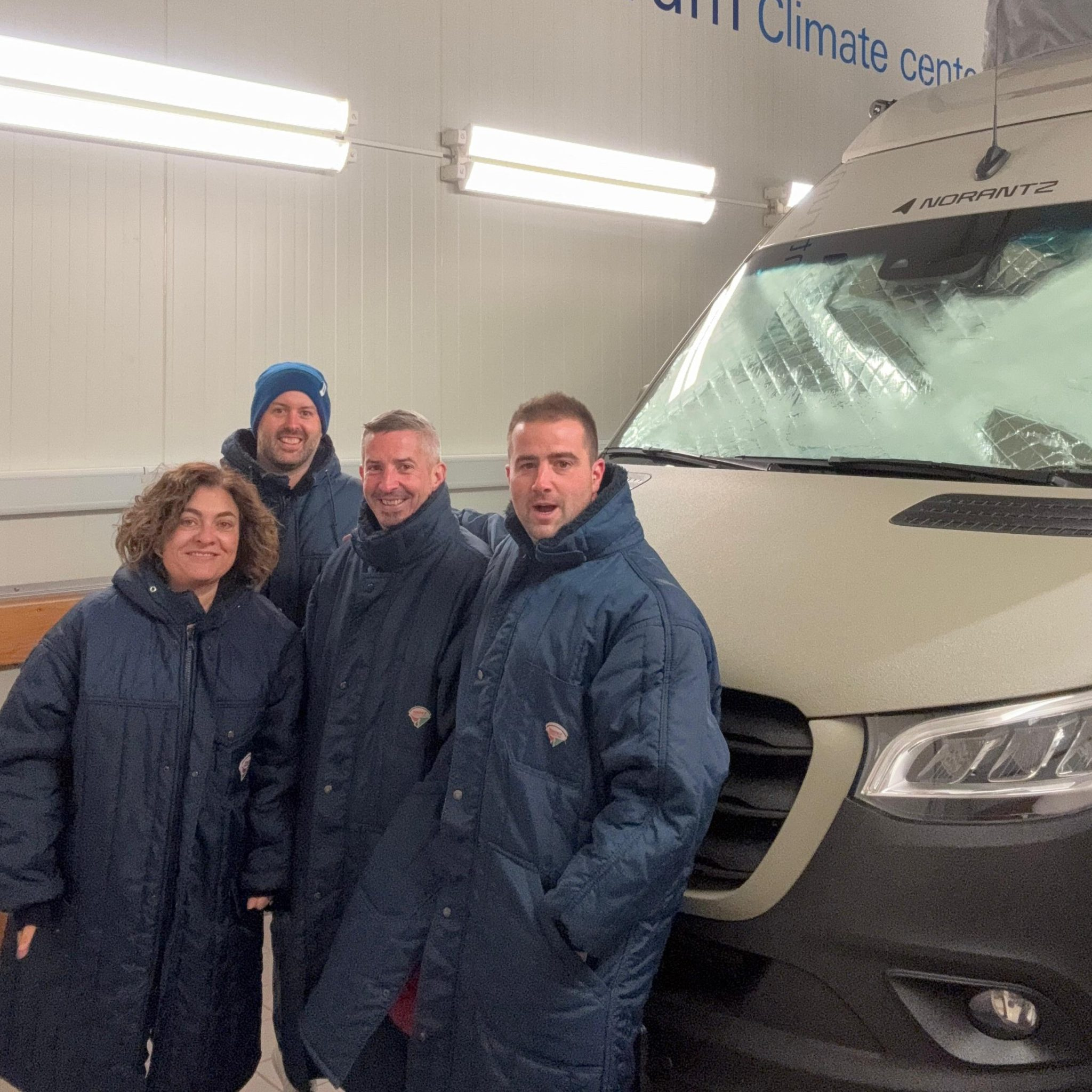 The team of experts from Norantz and Truma collaborating together inside the high-tech climate chamber, surrounded by measuring equipment and a campervan. El equipo de expertos de Norantz y Truma colaborando juntos dentro de la cámara climática de alta tecnología, rodeados de equipos de medición y una furgoneta camper.