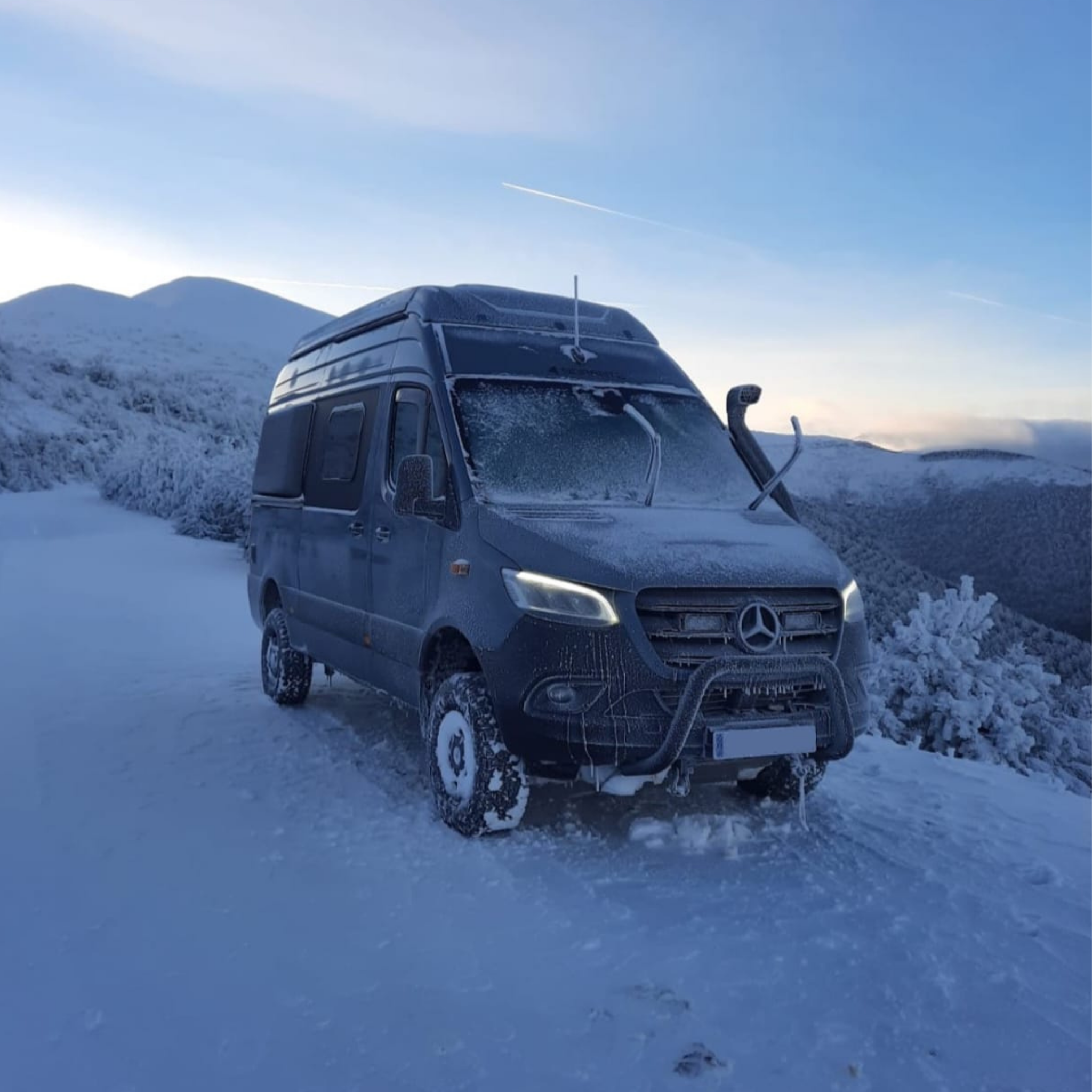 Norantz 4x4 campervan covered in frost and snow in a high-altitude mountain setting, demonstrating its insulation capabilities. Camper Norantz 4x4 cubierta de escarcha y nieve en un entorno de alta montaña, demostrando su capacidad de aislamiento.